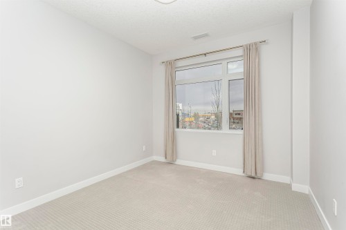 Empty room featuring carpet floors and a textured ceiling - 332 5151 Windermere Boulevard, Edmonton, AB - Indoor Photo Showing Other Room