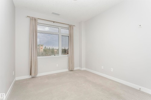 Carpeted empty room featuring a textured ceiling and baseboards - 332 5151 Windermere Boulevard, Edmonton, AB - Indoor Photo Showing Other Room