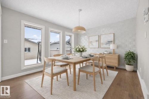 Dining space featuring an accent wall, wallpapered walls, wood finished floors, and a textured ceiling - 2435 Austin Crescent, Edmonton, AB - Indoor Photo Showing Dining Room