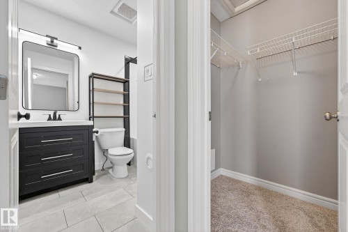 Bathroom with a walk in closet, vanity, and light tile patterned flooring - 2435 Austin Crescent, Edmonton, AB - Indoor Photo Showing Bathroom