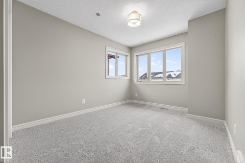 Carpeted spare room featuring baseboards and a textured ceiling - 2435 Austin Crescent, Edmonton, AB - Indoor Photo Showing Other Room