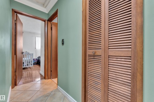 Bedroom with wood finished floors, a textured ceiling, a ceiling fan, wallpapered walls, and connected bathroom - 5504 18 Avenue, Edmonton, AB - Indoor Photo Showing Bedroom