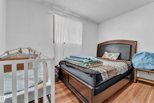 Bedroom with wood finished floors and a textured ceiling - 5504 18 Avenue, Edmonton, AB - Indoor Photo Showing Bedroom