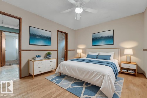 Bedroom with light wood finished floors, ceiling fan, and ensuite bathroom - 5504 18 Avenue, Edmonton, AB - Indoor Photo Showing Bedroom