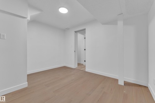 Unfurnished bedroom with light wood finished floors and a textured ceiling - 5504 18 Avenue, Edmonton, AB - Indoor Photo Showing Other Room