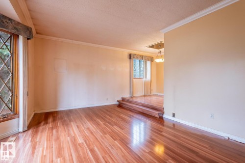 Spare room with light wood-style floors, ornamental molding, and a textured ceiling - 5504 18 Avenue, Edmonton, AB - Indoor Photo Showing Other Room