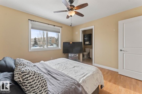 Bedroom with light wood-style flooring, a ceiling fan, and connected bathroom - 7 1001 7 Avenue, Cold Lake, AB - Indoor Photo Showing Bedroom