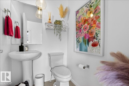 Half bath featuring toilet and baseboards - 6609 47 Avenue, Beaumont, AB - Indoor Photo Showing Bathroom