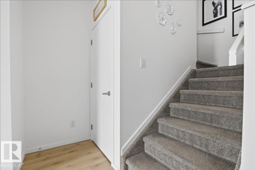 Stairs featuring baseboards and wood finished floors - 6609 47 Avenue, Beaumont, AB - Indoor Photo Showing Other Room