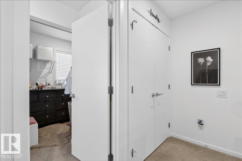 Hall with light carpet and baseboards - 6609 47 Avenue, Beaumont, AB - Indoor Photo Showing Other Room