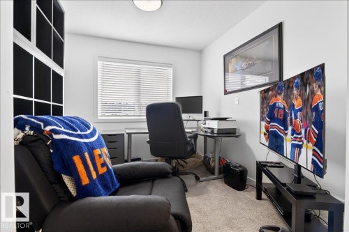 Carpeted office space featuring a textured ceiling and baseboards - 6609 47 Avenue, Beaumont, AB - Indoor Photo Showing Office