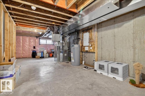Below grade area with electric water heater and electric panel - 6609 47 Avenue, Beaumont, AB - Indoor Photo Showing Basement