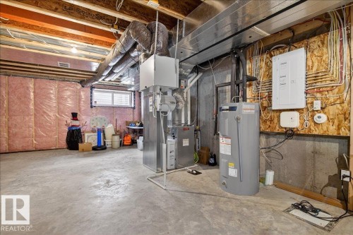 Basement featuring electric panel, electric water heater, and heating unit - 6609 47 Avenue, Beaumont, AB - Indoor Photo Showing Basement
