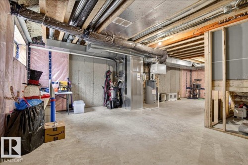 Unfinished below grade area with heating unit and water heater - 6609 47 Avenue, Beaumont, AB - Indoor Photo Showing Basement