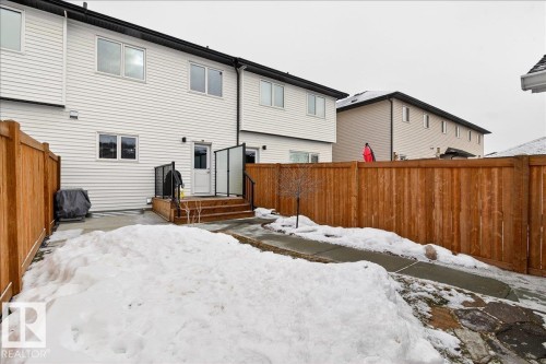 Snow covered back of property with a fenced backyard and a patio area - 6609 47 Avenue, Beaumont, AB - Outdoor With Exterior
