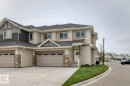 View of front of house with stone siding, driveway, a shingled roof, and an attached garage - 41 4835 Wright Drive, Edmonton, AB  - Outdoor With Facade 