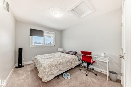 Bedroom with attic access, light carpet, and a textured ceiling - 41 4835 Wright Drive, Edmonton, AB - Indoor Photo Showing Bedroom