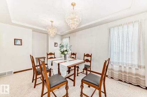 Dining space with a tray ceiling, a chandelier, and healthy amount of natural light - 777 Butterworth Drive, Edmonton, AB - Indoor Photo Showing Dining Room