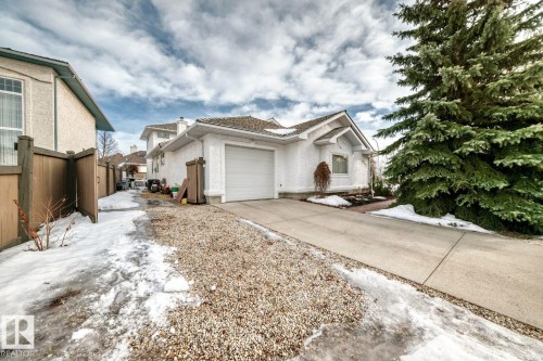 View of front of property featuring an attached garage, a chimney, and concrete driveway - 777 Butterworth Drive, Edmonton, AB - Outdoor