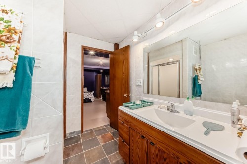 Bathroom featuring tile walls, a stall shower, vanity, and dark tile patterned flooring - 777 Butterworth Drive, Edmonton, AB - Indoor Photo Showing Bathroom