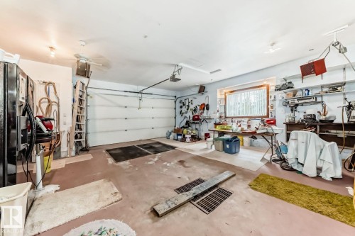 Garage featuring black fridge with ice dispenser and a ceiling fan - 777 Butterworth Drive, Edmonton, AB - Indoor Photo Showing Garage