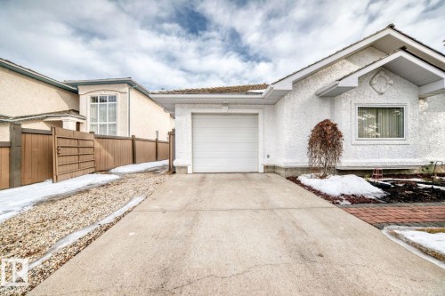 View of front of property featuring stucco siding, an attached garage, and driveway - 777 Butterworth Drive, Edmonton, AB - Outdoor