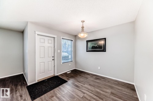 Foyer entrance with dark wood-style flooring and baseboards - 2823 Duke Crescent, Edmonton, AB - Indoor Photo Showing Other Room
