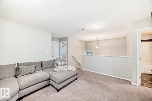 Carpeted living room featuring a textured ceiling and baseboards - 2823 Duke Crescent, Edmonton, AB - Indoor Photo Showing Living Room