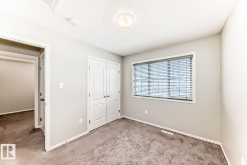 Unfurnished bedroom featuring carpet floors, a closet, and a textured ceiling - 2823 Duke Crescent, Edmonton, AB - Indoor Photo Showing Other Room