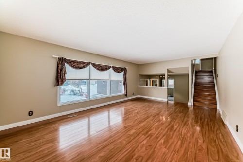 Unfurnished living room with stairs and wood finished floors - 38 Lancaster Crescent, St. Albert, AB - Indoor Photo Showing Other Room