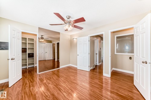 Unfurnished bedroom featuring light wood-style flooring, a walk in closet, and a ceiling fan - 38 Lancaster Crescent, St. Albert, AB - Indoor Photo Showing Other Room