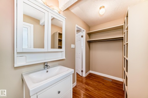 Bathroom featuring vanity, dark wood-style flooring, and a textured ceiling - 38 Lancaster Crescent, St. Albert, AB - Indoor Photo Showing Bathroom