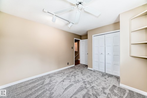Unfurnished bedroom featuring rail lighting, carpet, ceiling fan, and a closet - 38 Lancaster Crescent, St. Albert, AB - Indoor Photo Showing Other Room