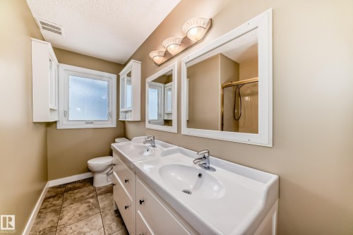 Bathroom with an enclosed shower, double vanity, and a textured ceiling - 38 Lancaster Crescent, St. Albert, AB - Indoor Photo Showing Bathroom
