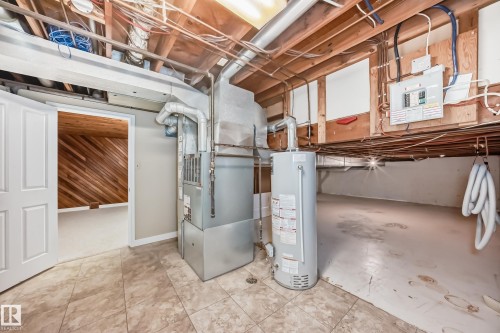 Unfinished basement featuring water heater and heating unit - 38 Lancaster Crescent, St. Albert, AB - Indoor Photo Showing Basement