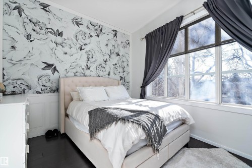 Bedroom with wallpapered walls, an accent wall, and wood finished floors - 302 10905 109 Street, Edmonton, AB - Indoor Photo Showing Bedroom