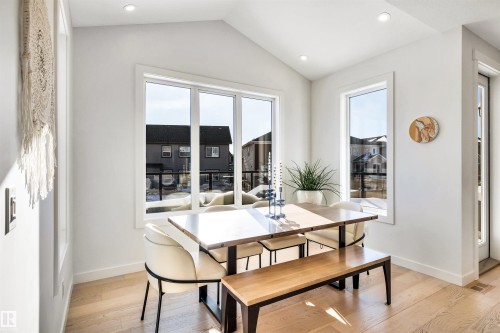 Dining room with light wood-type flooring, healthy amount of natural light, recessed lighting, and vaulted ceiling - 11 Promenade Point(E), Beaumont, AB - Indoor Photo Showing Dining Room