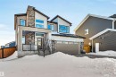 View of front of property featuring stone siding, stucco siding, and an attached garage - 11 Promenade Point(E), Beaumont, AB  - Outdoor 