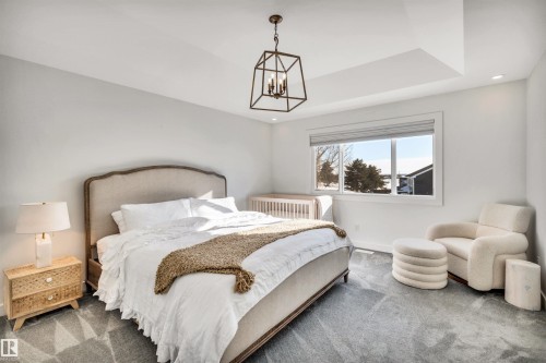 Bedroom with carpet floors and a chandelier - 11 Promenade Point(E), Beaumont, AB - Indoor Photo Showing Bedroom