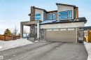 Contemporary house featuring stone siding, a garage, and concrete driveway - 11 Promenade Point(E), Beaumont, AB  - Outdoor 