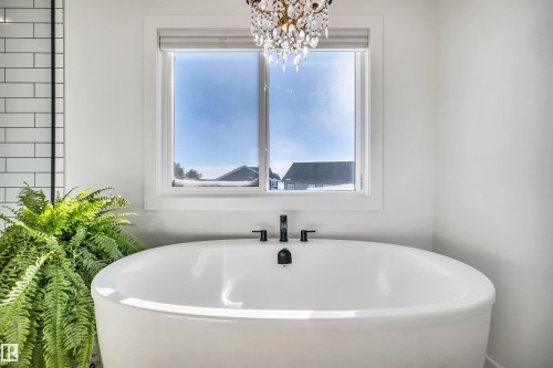 Bathroom featuring a freestanding tub and hanging lights - 11 Promenade Point(E), Beaumont, AB - Indoor Photo Showing Bathroom