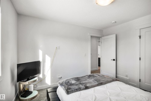 Bedroom featuring baseboards - 11 Promenade Point(E), Beaumont, AB - Indoor Photo Showing Bedroom