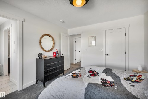 Carpeted bedroom with baseboards and a textured ceiling - 11 Promenade Point(E), Beaumont, AB - Indoor Photo Showing Bedroom
