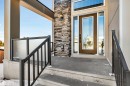 View of exterior entry with stone siding and a patio area - 11 Promenade Point(E), Beaumont, AB  - Outdoor With Exterior 