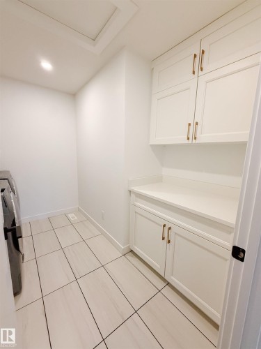 Laundry room with light tile patterned floors and recessed lighting - 11 Promenade Point(E), Beaumont, AB - Indoor