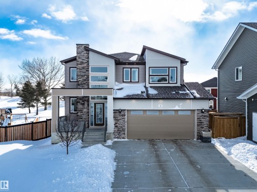 Modern home with stone siding, concrete driveway, and a garage - 11 Promenade Point(E), Beaumont, AB - Outdoor