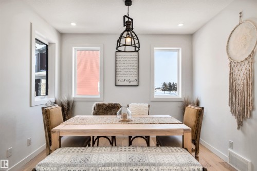 Dining room with light wood finished floors and baseboards - 11 Promenade Point(E), Beaumont, AB - Indoor Photo Showing Dining Room