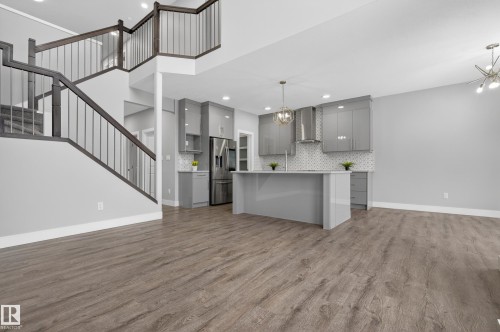 Kitchen with gray cabinetry, open floor plan, a chandelier, and modern cabinets - 3224 160 Street, Edmonton, AB - Indoor Photo Showing Kitchen With Upgraded Kitchen