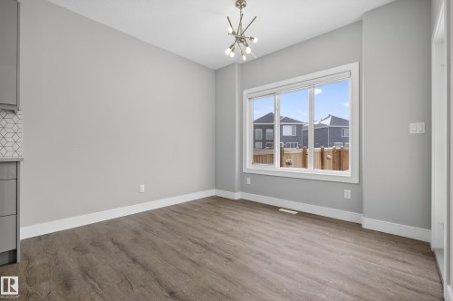 Unfurnished dining area featuring a chandelier and light wood-style floors - 3224 160 Street, Edmonton, AB - Indoor Photo Showing Other Room