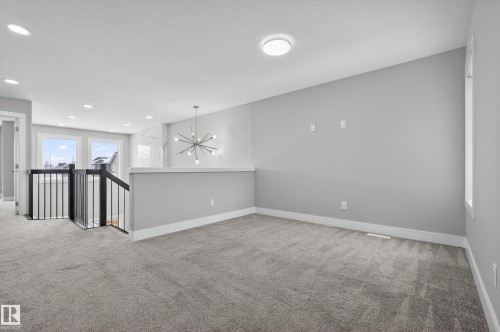 Spare room with light colored carpet and a chandelier - 3224 160 Street, Edmonton, AB - Indoor Photo Showing Other Room